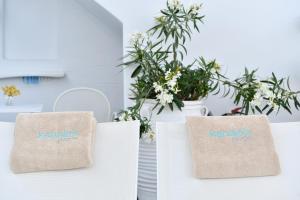 two bags with the word kamarks on them in front of plants at Kanale's Rooms & Suites in Naousa
