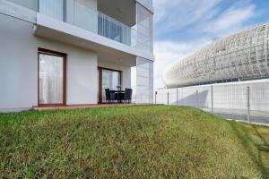 a building with a grassy yard next to a building at Apartments Supernova near Tauron Arena by Renters in Krakow