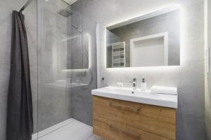 a bathroom with a sink and a shower with a mirror at Apartments Supernova near Tauron Arena by Renters in Krakow