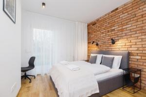 a bedroom with a bed and a brick wall at Apartments Supernova near Tauron Arena by Renters in Krakow