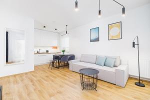 a living room with a white couch and a table at Apartments Supernova near Tauron Arena by Renters in Krakow