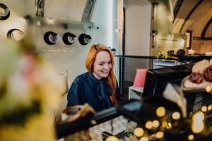 チェスキー・クルムロフにあるクルムロブスカ ポハトカのパン屋のカウンターの後ろで微笑んでいる女性