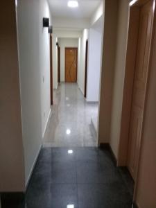 a hallway with white walls and a tile floor at Hotel Itabira in Itabira