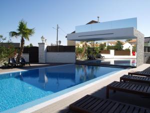 - une piscine avec deux chaises longues à côté d'un bâtiment dans l'établissement Quinta Do Molinu, à Lourinhã
