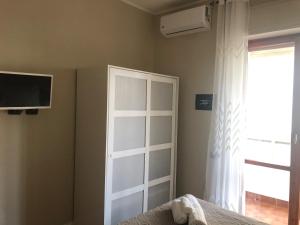 sypialnia z białymi drzwiami i oknem w obiekcie GISELLE HOUSE w Cagliari