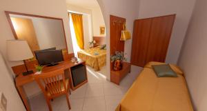 a small room with a bedroom with a bed and a desk at Hotel Solaria in Rodi Garganico