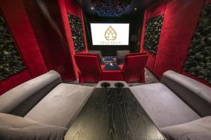 a cinema room with red chairs and a projection screen at Erla Villa in Eger