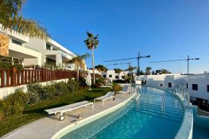 una piscina con bancos junto a un edificio en Amazing Exclusive House in Marbella Golden Mile, en Marbella