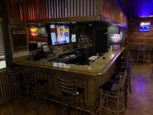 a bar in a restaurant with chairs and a television at Travelodge by Wyndham Odessa in Odessa +20 photos