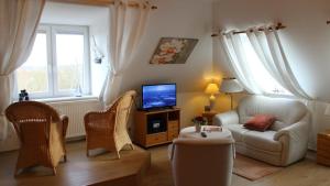 a living room with a couch and a tv at PEMATRA Ferienwohnung Marwin in Travemünde