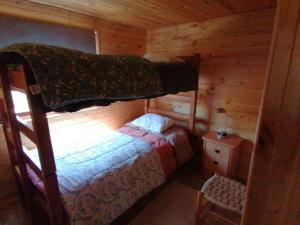 - une chambre avec des lits superposés dans une cabane en rondins dans l'établissement Cabaña sol y luna, à El Quisco