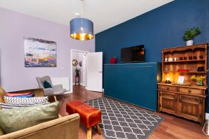 Lovely Abode in Newcastle - Sleeps 4 في نيوكاسل أبون تاين: غرفة معيشة بحائط ازرق