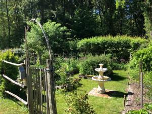 a garden with a bird bath in the grass at Domaine de la Juranvillerie, gîte et chambres d'hôtes in Rigny-Ussé