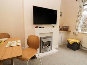 a living room with a fireplace with a flat screen tv at Cosy Bee in Morecambe