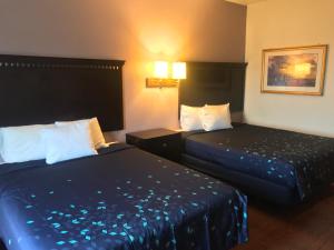 a hotel room with two beds with blue sheets at Pier Inn in Luna Pier