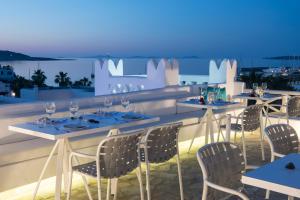 a restaurant with tables and chairs on a roof at Kanale's Rooms & Suites in Naousa