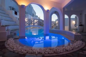 a swimming pool in a building with a bridge at Kanale's Rooms & Suites in Naousa