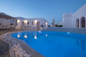 a swimming pool in a villa at night at Kanale's Rooms & Suites in Naousa