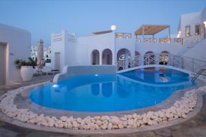 a pool in the middle of a house with rocks around it at Kanale's Rooms & Suites in Naousa
