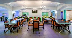 a dining room with tables and chairs at Best Western Plus Orlando Lake Buena Vista South Inn & Suites in Kissimmee