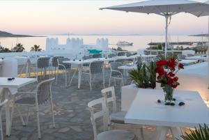a group of tables and chairs with a view of the ocean at Kanale's Rooms & Suites in Naousa