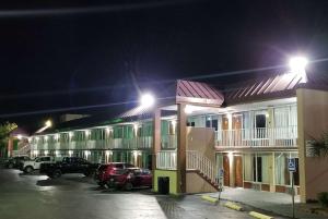 um hotel com carros estacionados num parque de estacionamento à noite em Days Inn & Suites by Wyndham Charleston Airport West em Charleston