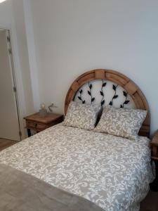 a bedroom with a bed with a wooden headboard and pillows at Céntrico y con encanto en tierra de vinos in Logroño