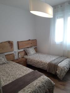 a bedroom with two beds and a large window at Céntrico y con encanto en tierra de vinos in Logroño