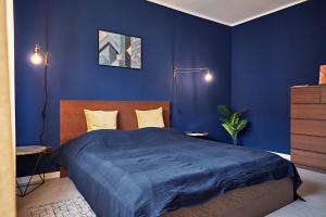 una camera da letto con pareti blu e un grande letto di “Botanica” near Venice a Spinea