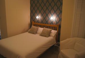 a bedroom with a bed with two pillows and a chair at Hotel 50 in Bournemouth