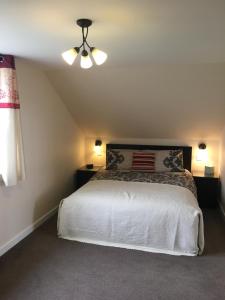 a bedroom with a white bed and a ceiling fan at Runa Guest House in Twatt