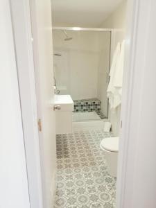 a white bathroom with a toilet and a sink at Singular Ronda Apartment in Ronda