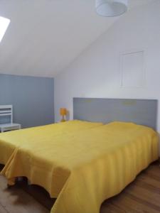 - une chambre avec un lit jaune dans l'établissement Gite BR Al Buga, au Bugue