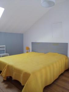 1 dormitorio con 1 cama amarilla en una habitación en Gite BR Al Buga, en Le Bugue