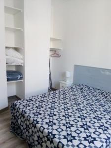 1 dormitorio con 1 cama con edredón blanco y negro en Gite BR Al Buga, en Le Bugue