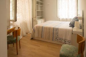 1 dormitorio con cama, escritorio y ventana en BREZZA MARINA, en Roma