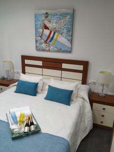 Un dormitorio con una cama con una bandeja de bebidas. en Blanco y López, en Cee