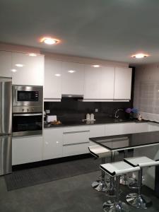 une cuisine avec des armoires blanches et des appareils en acier inoxydable dans l'établissement Blanco y López, à Cee