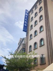 a building with a blue sign on the side of it at Good Ground Hotel Tainan in Tainan