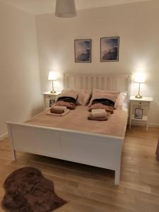 una camera da letto con un grande letto bianco con due lampade di Apartman Viktoria a Tuzla