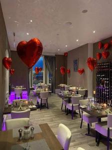 a restaurant with red heart balloons hanging from the ceiling at Halvard Hotel in Douglas