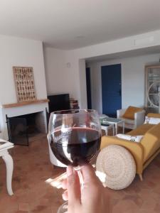 a person holding a glass of wine in a living room at Cortijo el Puente in Viñuela