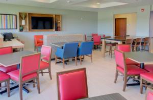 un comedor con mesas y sillas coloridas en Holiday Inn Express & Suites Le Mars, an IHG Hotel en Le Mars