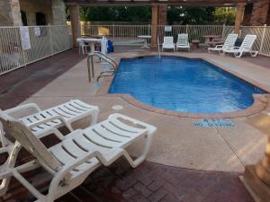 una piscina con 2 tumbonas junto a ella en La Copa Inn Alamo, en Alamo