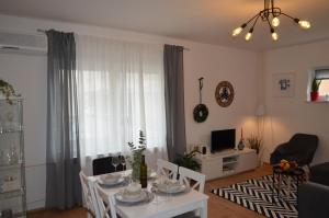 a living room with a white table and chairs at Apartman 19:14 in Bjelovar