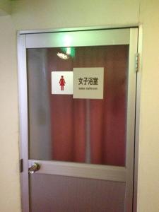 eine Tür mit einem Schild auf einem Zimmer in der Unterkunft Naeba Musashi in Yuzawa