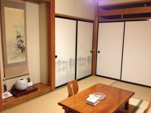 a dining room with a table and a room with sliding doors at Naeba Musashi in Yuzawa