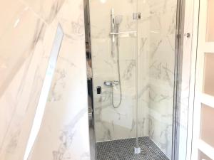 a shower in a bathroom with white marble at Studio neuf et cosy au centre de Paris in Paris