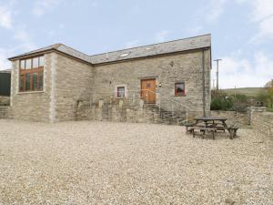 a stone house with a picnic table in front of it at The Old Barn in Swanage
