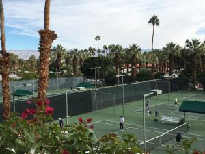 eine Gruppe von Leuten, die Tennis auf einem Tennisplatz spielen in der Unterkunft GetAways at Palm Springs Tennis Club in Palm Springs